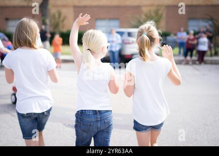 Young Girls Waving in Community Parade Stock Photo