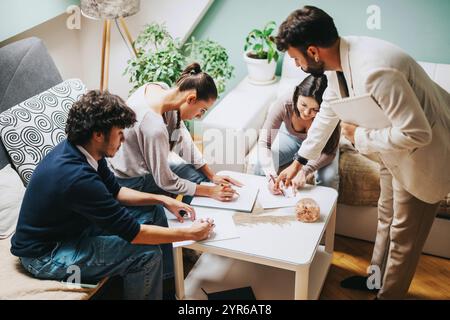 High school students collaborating on a project with professor guidance Stock Photo