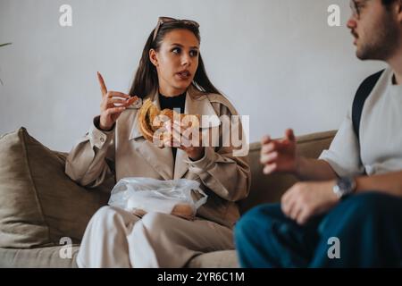 Students sitting together, sharing breakfast and engaging in conversation during a break from school activities. Stock Photo