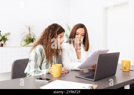 Two women collaborating on a project in a corporate office environment Stock Photo
