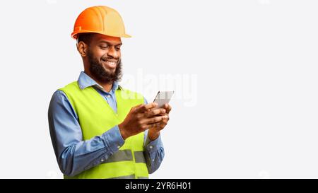 African Builder Worker Using Smartphone On White Studio Background, Panorama Stock Photo