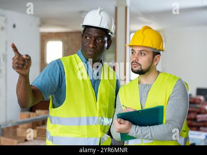 Two engineers discussing work in apartment Stock Photo