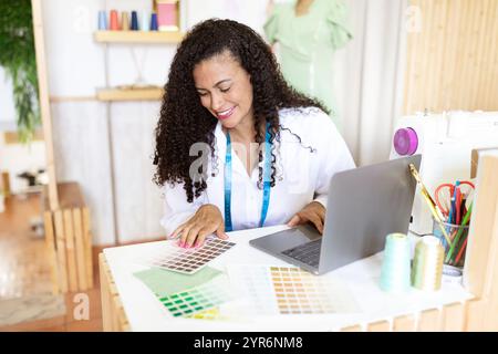 Creative designer working at her office with color swatches and laptop Stock Photo