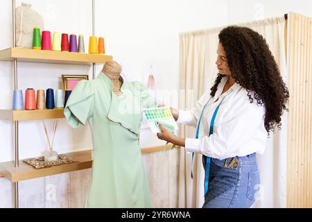 Mature woman designer coordinating colors for fashion creation in studio Stock Photo