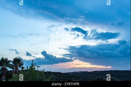 Blue skies and cloudscape along a grass and tree horizon. Photo taken on an evening in San Antonio Texas during twilight Stock Photo
