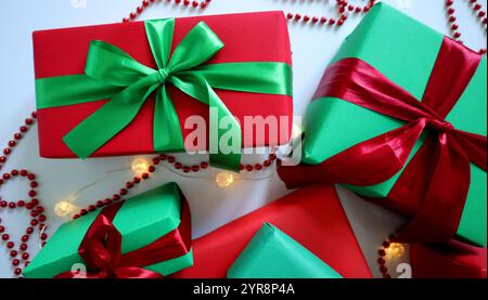 Set of gifts on a white background. Traditional Christmas red and green colors. Boxes of different sizes. Tied with ribbons and bows. Around a garland Stock Photo