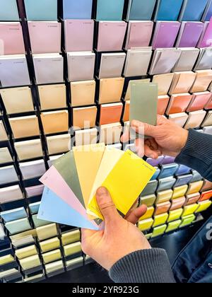 Customer Selecting Paint Swatches in Colourful Hardware Store Display. High quality photo Stock Photo
