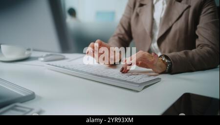 Close up of Caucasian unrecognizable businesswoman typing on keyboard, chatting with client or business partner using PC. Marketing manager or financial specialist works in modern office. E-commerce. Stock Photo