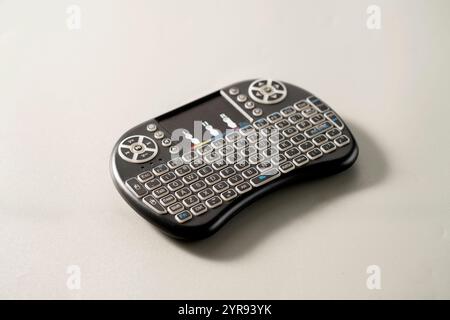 A remote control in the form of a keyboard to control a TV box on light grey background Stock Photo