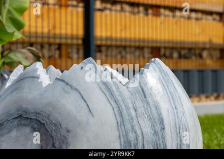 Large broken marble egg as a water fountain in a stone bed. High quality photo Stock Photo