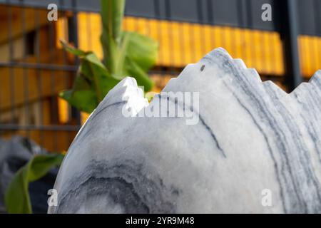 Large broken marble egg as a water fountain in a stone bed. High quality photo Stock Photo