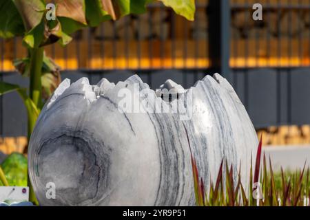 Large broken marble egg as a water fountain in a stone bed. High quality photo Stock Photo