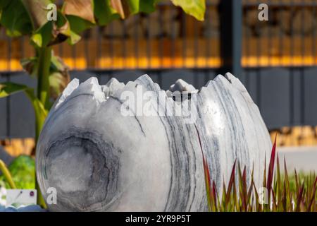 Large broken marble egg as a water fountain in a stone bed. High quality photo Stock Photo