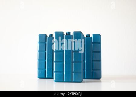 Three blue, plastic, freezer or fridge cooling elements with gel. Close up studio shot, isolated on white, no people. Stock Photo
