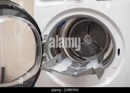 cleanup lints and dirt from tumble dryer filter. Clothes dryer lint filter that is covered with lint. Taking the lint out from dirty air filter of the Stock Photo