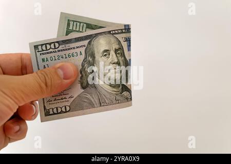 Dollars in a man's hand on a white background. 100 American dollars in hand. The man pulls his hand crumpled new bill. Stock Photo