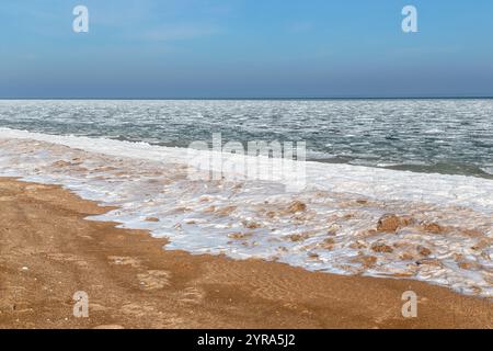 This is frozen Azov with ice floes near the coast and an frozen surf on a sandy beach. Stock Photo