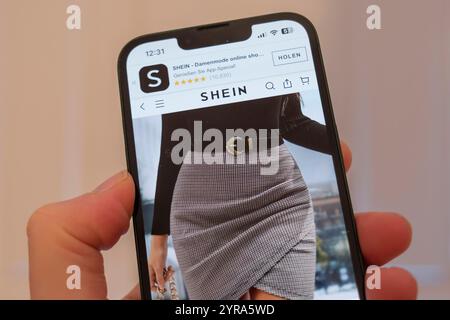 Hand holding a mobile phone showing the website of the Stock Photo