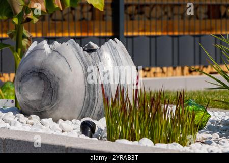Large broken marble egg as a water fountain in a stone bed. High quality photo Stock Photo
