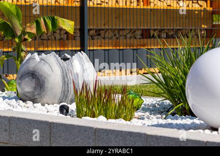 Large broken marble egg as a water fountain in a stone bed. High quality photo Stock Photo