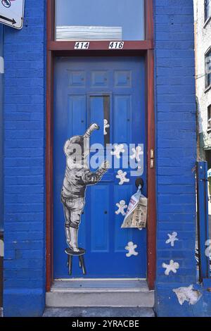Canada, Quebec, Montreal, Rachel Est Street: street art. Collage of a child standing on a stool with character-shaped cakes (gingerbread man) on the b Stock Photo