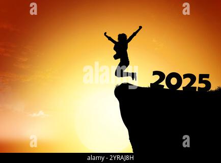 Silhouette of a person jumping joyfully at sunset while celebrating the arrival of 2025 Stock Photo