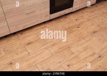 Empty place for carpet, mat or text. Top view. Ceramic Wood Floor Tiles on Kitchen, walnut ceramic floor. Beige Furniture at Kitchen. Stock Photo