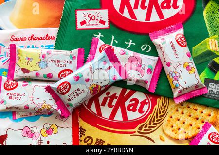 Assortment of various types of Japanese kit kat mini bars. Top down view of several kitkat bars laid out on packets of different flavours. Stock Photo