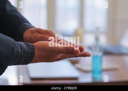 A young businessman uses alcohol gel prepared in the office to wash his hands after attending a meeting to clean his hands and disinfect the virus dur Stock Photo