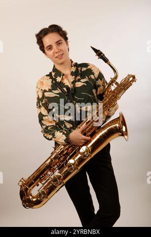 Young Musician holding or playing a baritone saxophone. Stock Photo