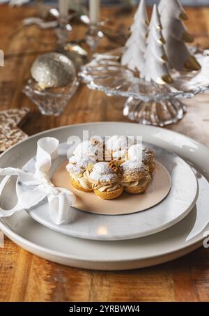 Delicious paris brest pastry sprinkled with icing sugar on Christmas table setting Stock Photo