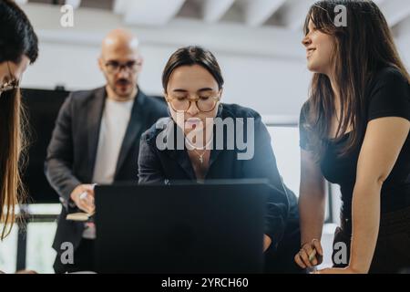 Students collaborating on a project with professor guidance Stock Photo