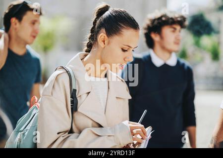High school students collaborating outdoors with professor guidance Stock Photo