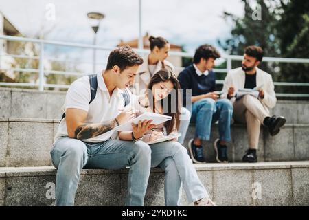Students collaborating with professor outdoors on university campus Stock Photo