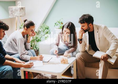 High school students collaborating on a project with professor at home Stock Photo