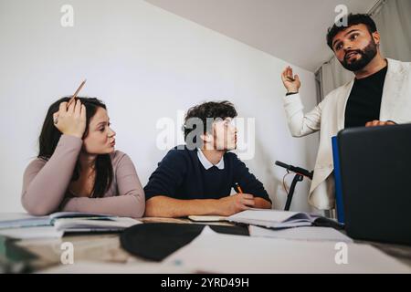 High school students collaborating on a project with teacher guidance Stock Photo