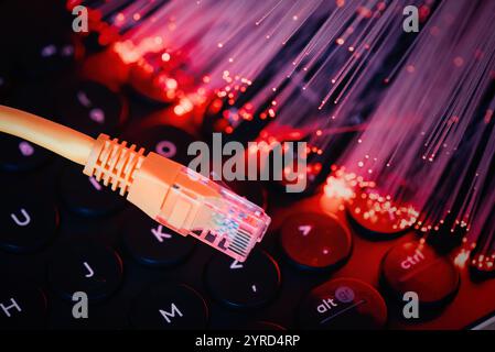 Ethernet cable on computer keyboard. Fast internet concept with optical fiber Stock Photo