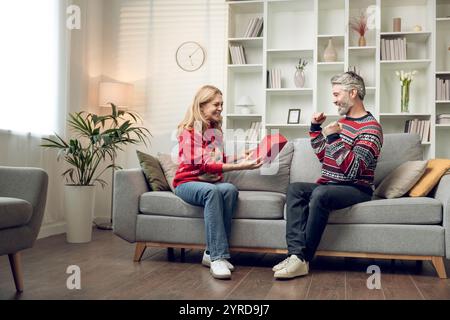 Happy couple exchanging presents for christmas and feeling enjoyed Stock Photo