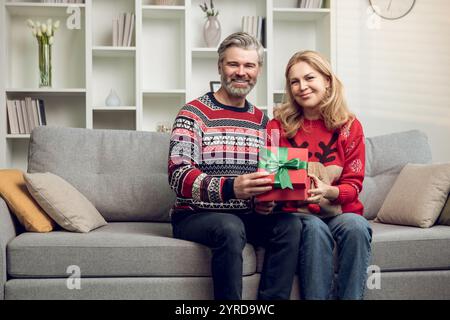 Happy couple exchanging presents for christmas and feeling enjoyed Stock Photo