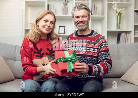 Happy couple exchanging presents for christmas and feeling enjoyed Stock Photo