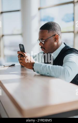 Focused business worker using smart phone at modern office desk Stock Photo