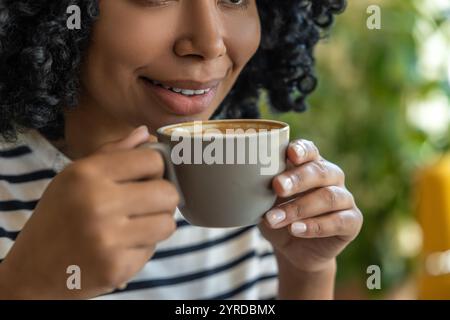 Close up of a womans face and hands with a cup of coffee Stock Photo