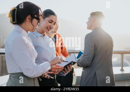 Diverse business team collaborating on rooftop during sunset Stock Photo