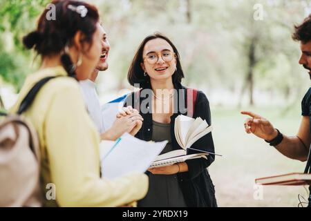 Multicultural students collaborating on school tasks in a park setting Stock Photo
