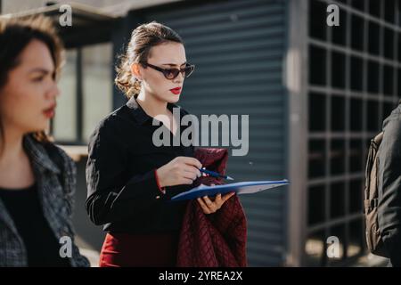 Multicultural team analyzing business statistics in outdoor meeting Stock Photo