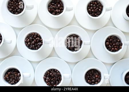 White coffee cups with coffee beans arranged on a white table, top view Stock Photo