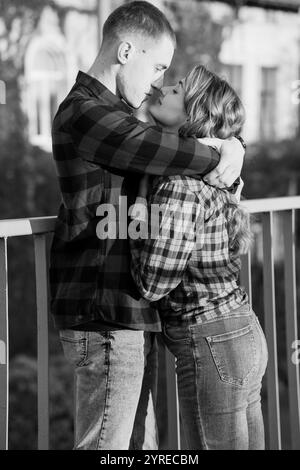Romantic Black and White Embrace of a Young Couple in Checkered Shirts. Stock Photo