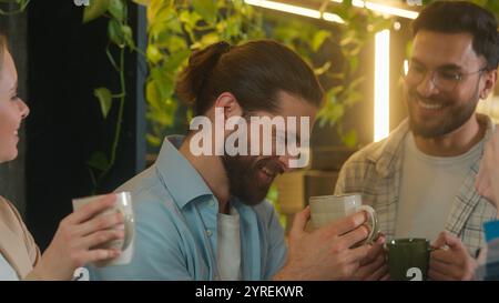 Multiethnic team business men women diverse girls guys colleagues friends coworkers students happy buddies drink coffee together office break talk Stock Photo