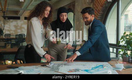 Team architects contractors engineers business colleagues Arabian Muslim Caucasian businessman businesswomen drink coffee break happy relaxed man Stock Photo