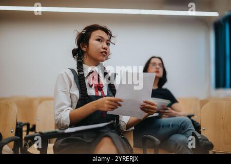 Students engaging in thoughtful discussion with a professor in classroom Stock Photo
